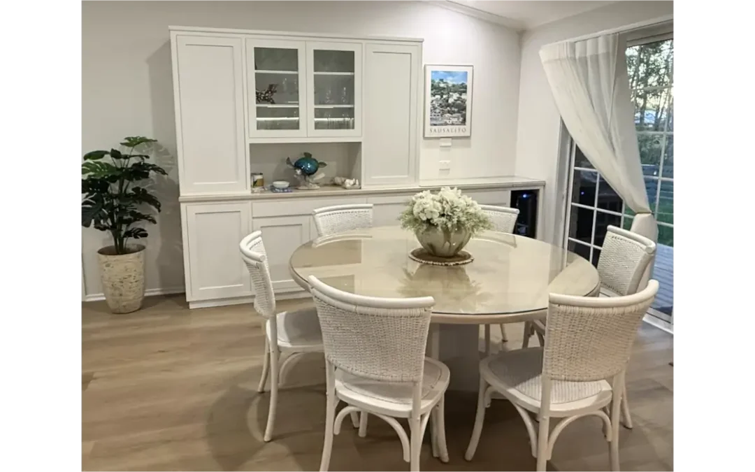 Bespoke white dining set with round table and woven chairs in a coastal home setting.