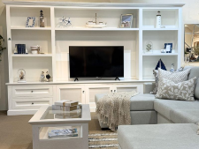 Custom made white wall unit with shelves, TV display, and decorative elements, showcasing Coastal Design Furniture's custom furniture offerings.