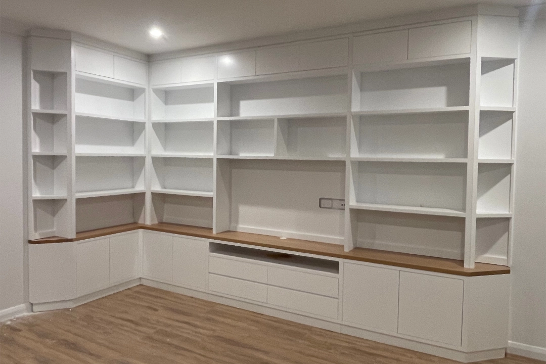 Custom-built white timber wall unit with open shelving and a wooden countertop, designed for maximizing space and style in Central Coast homes.