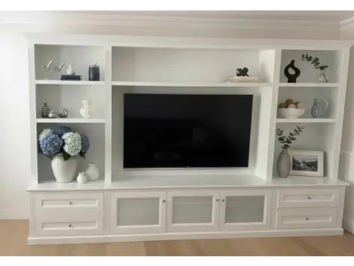 Coastal-Design-Furniture-white-custom-wall-unit-light-styled-1-510x384 Custom white wall unit featuring integrated television space, open shelving for decor, and concealed storage drawers, designed for maximizing functionality and style in home interiors.