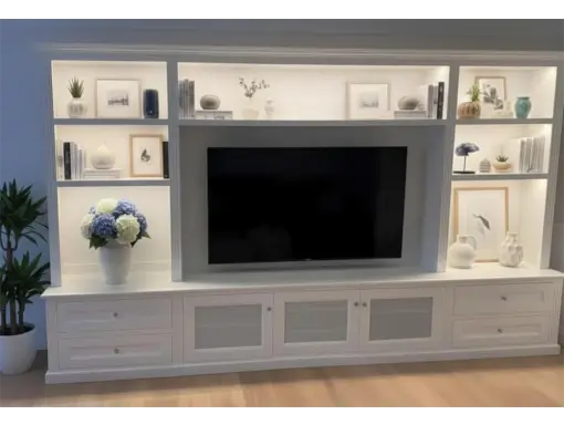 Coastal-Design-Furniture-white-custom-wall-unit-light-styled-2-510x384 Custom-built white wall unit with integrated TV, adjustable shelving, and decorative lighting, featuring personalized decor elements and a potted plant, designed for functionality and style in modern homes.
