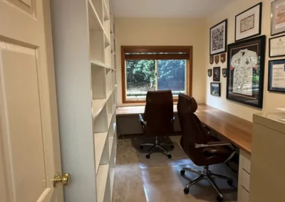 After photo. New custom executive home office, right angle desk, white wall unit for shelving. Installed by Coastal Design Furniture.